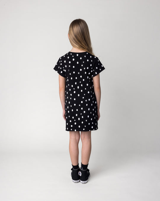Kid wearing the Spotty Dress in black, back view