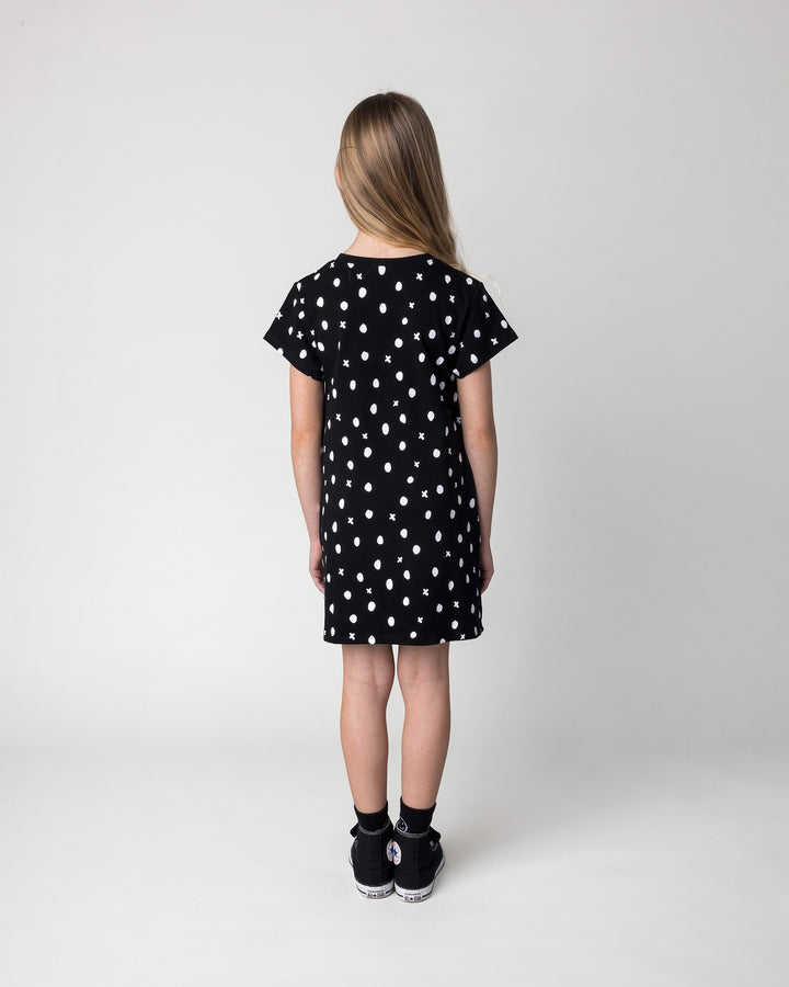 Kid wearing the Spotty Dress in black, back view