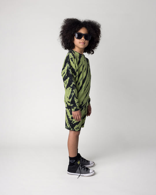 Kid wearing the Strike Crew in lime with the Strike Short in lime, side view