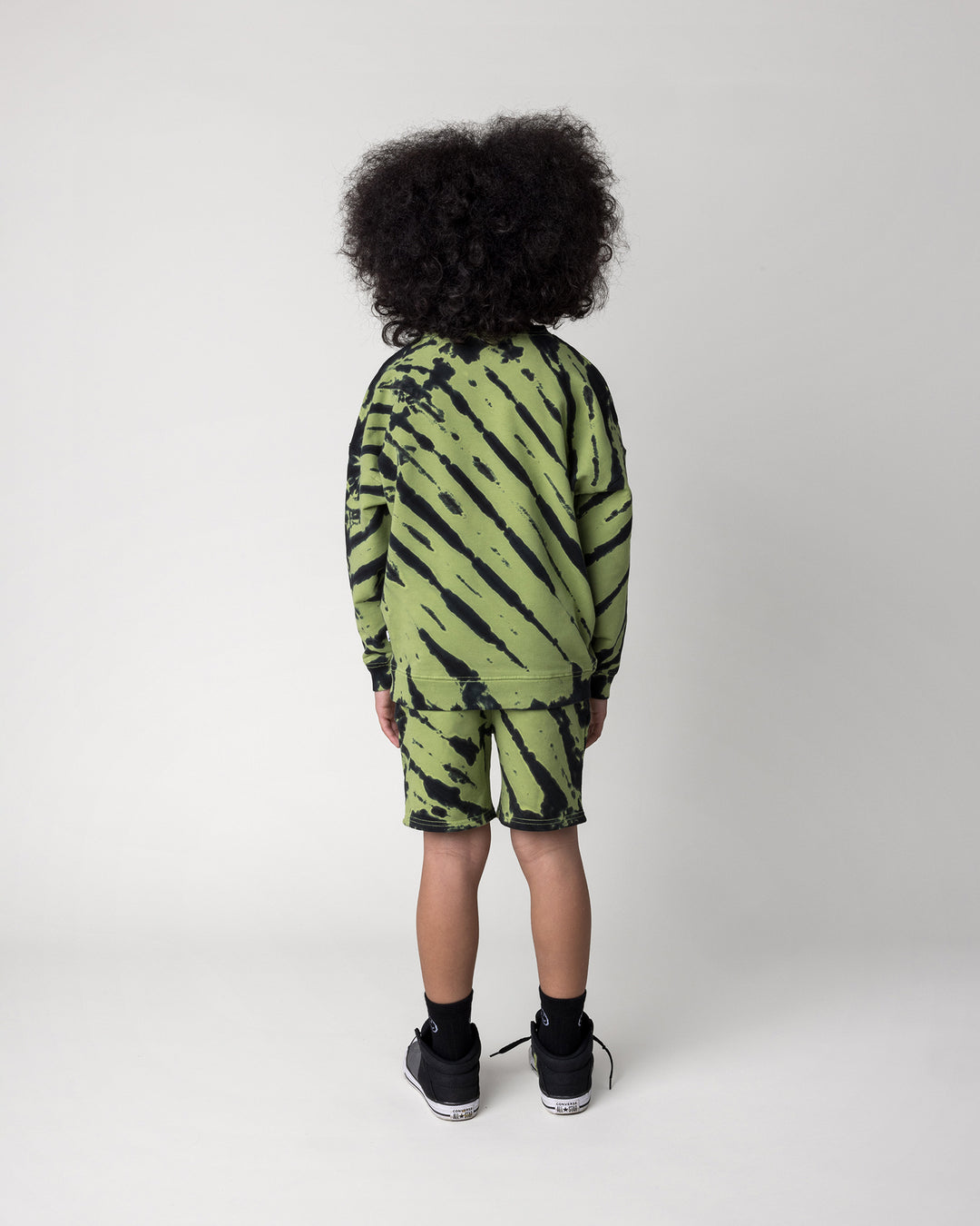 Kid wearing the Strike Crew in lime with the Strike Short in lime, back view