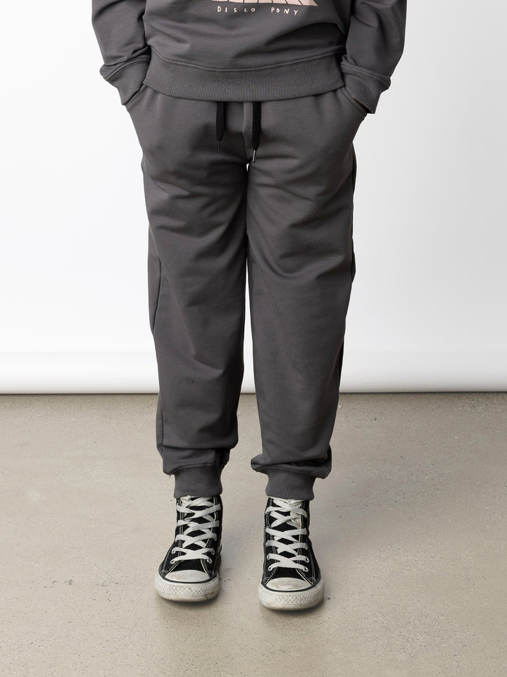 Minti kids clothing. Relaxed universal fit trackies with cosy side pockets, elasticated waistband, shoelace cord and 2x2 Rib cuffs. Small Minti embroidery on the back. 320 Gram // 95% Cotton // 5% Elastane.