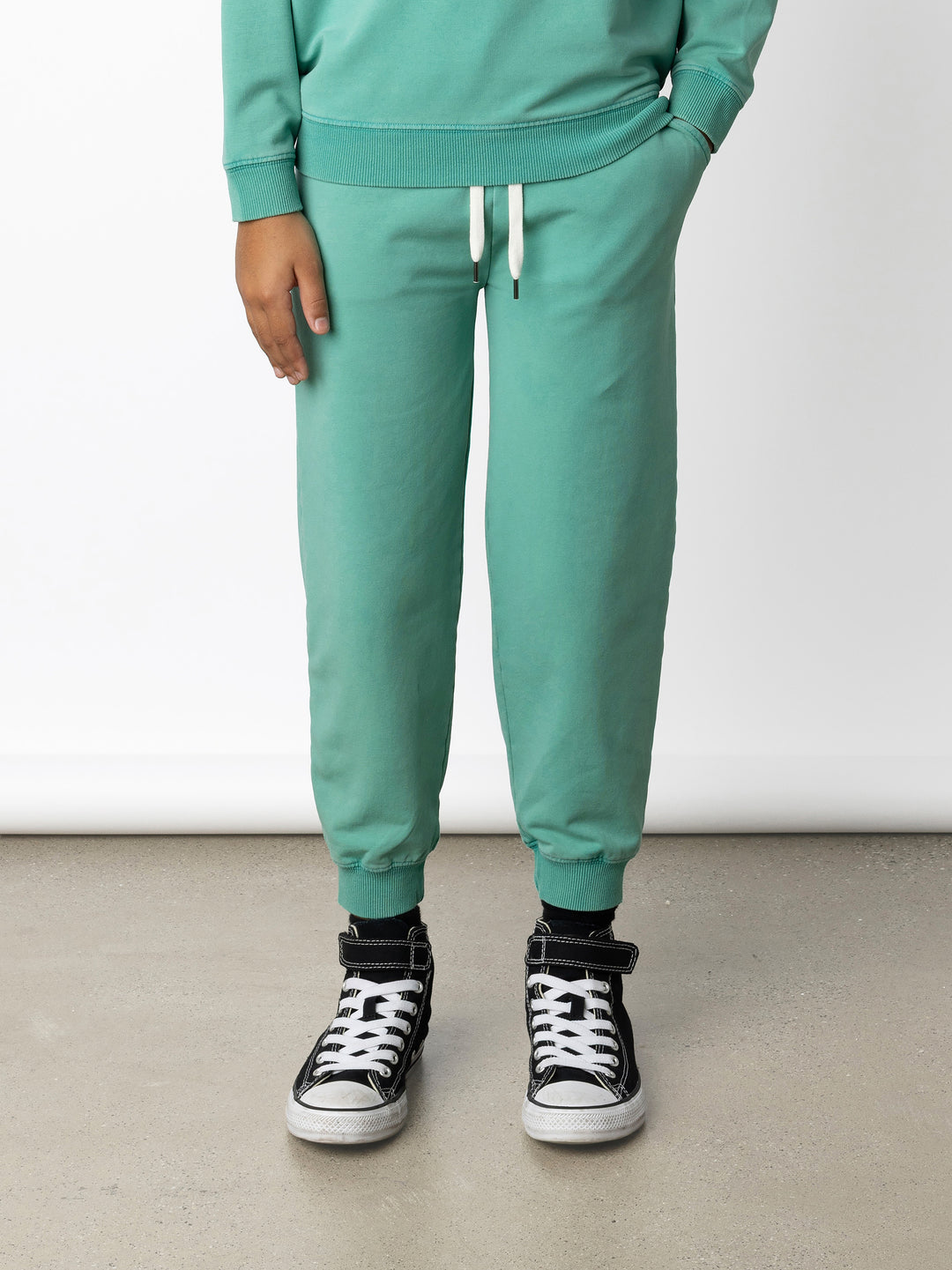 Minti kids clothing. Relaxed universal fit trackies with cosy side pockets, elasticated waistband, shoelace cord and 2x2 Rib cuffs. Small Minti embroidery on the back. 260 Gram // 95% Cotton // 5% Elastane.