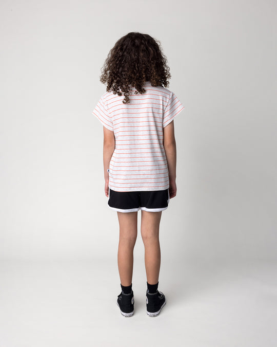 Kid wearing the Sprint Short in black and white with the Happy Tiger Tee in marle and coral stripe, back view