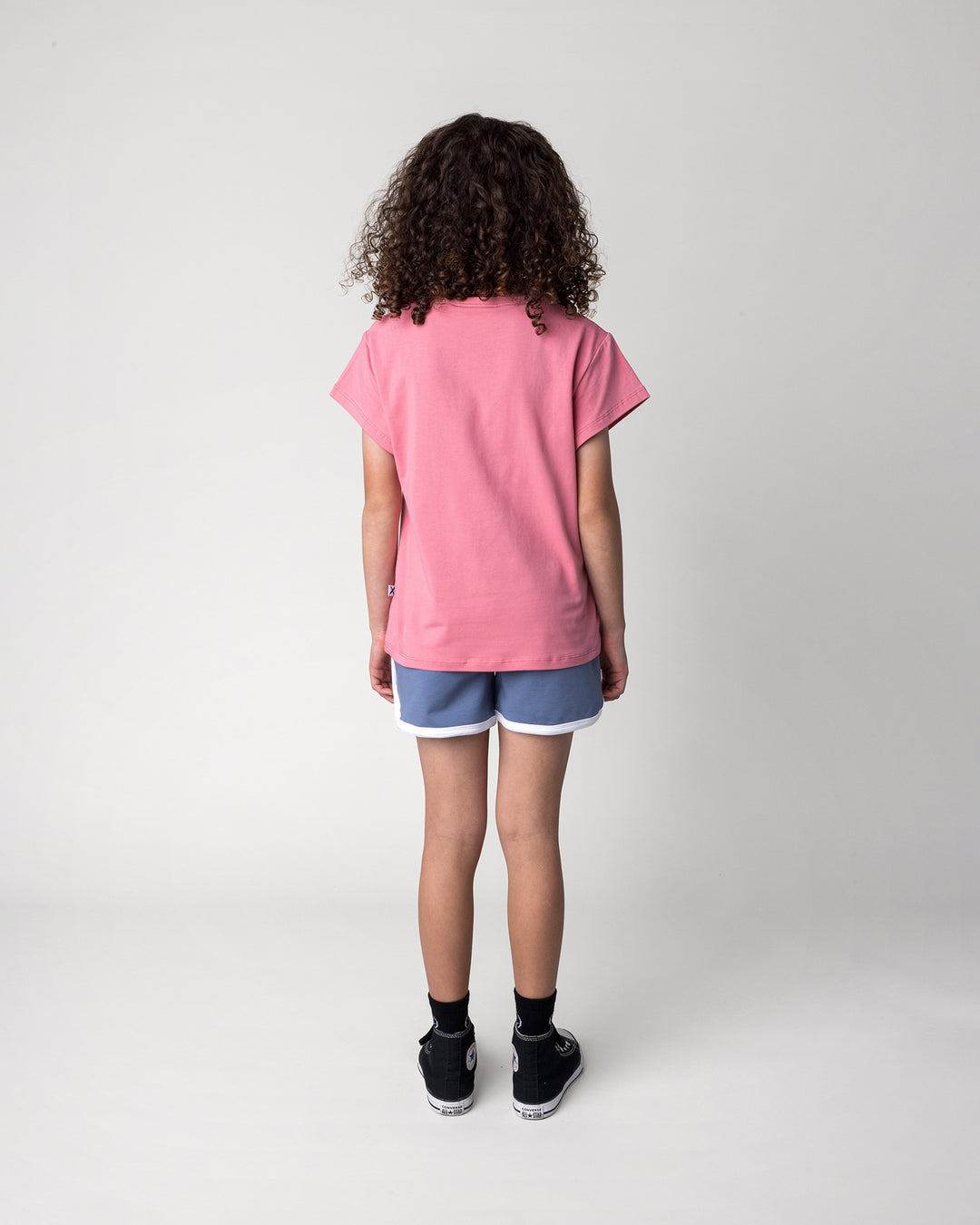 Kid wearing the Sprint Short in cornflower and white with the Cool Crew Tee in candy, back view