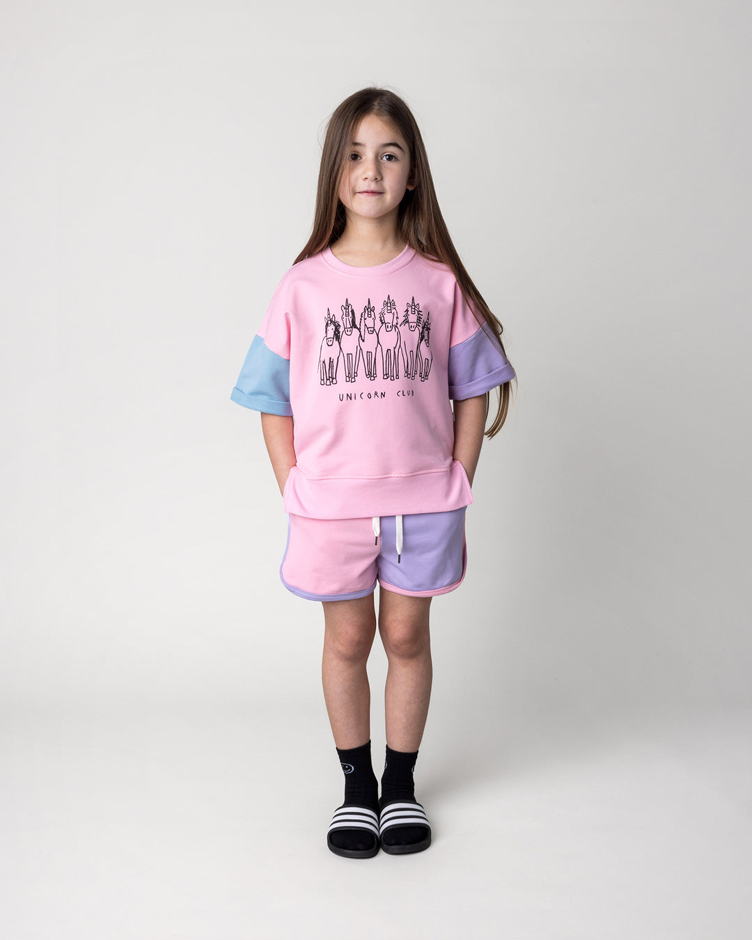 Kid wearing the Sprint Short in pink, purple and aqua with the Unicorn Club Short Sleeve Crew in pink, purple and aqua, front view