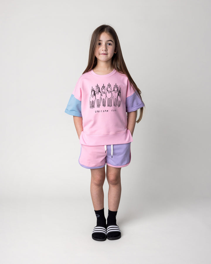 Kid wearing the Sprint Short in pink, purple and aqua with the Unicorn Club Short Sleeve Crew in pink, purple and aqua, front view