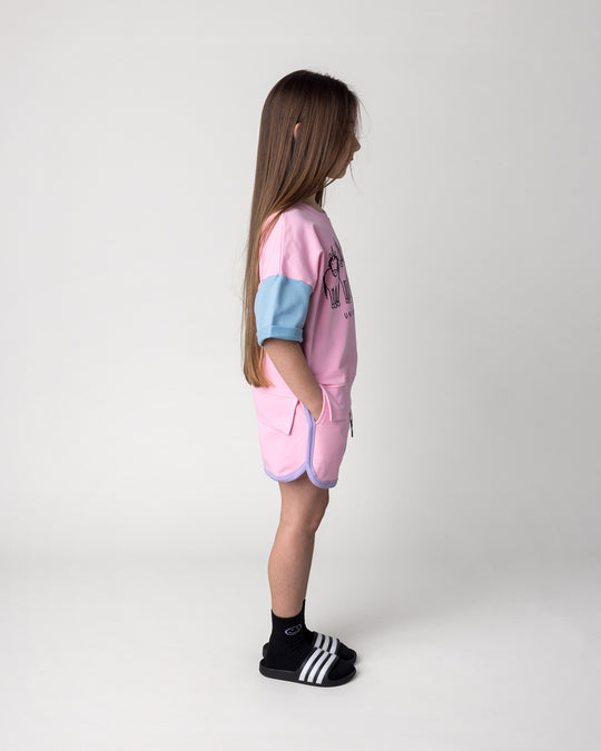 Kid wearing the Sprint Short in pink, purple and aqua with the Unicorn Club Short Sleeve Crew in pink, purple and aqua, side view