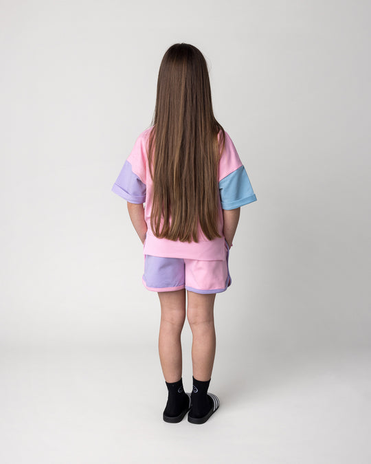 Kid wearing the Sprint Short in pink, purple and aqua with the Unicorn Club Short Sleeve Crew in pink, purple and aqua, back view