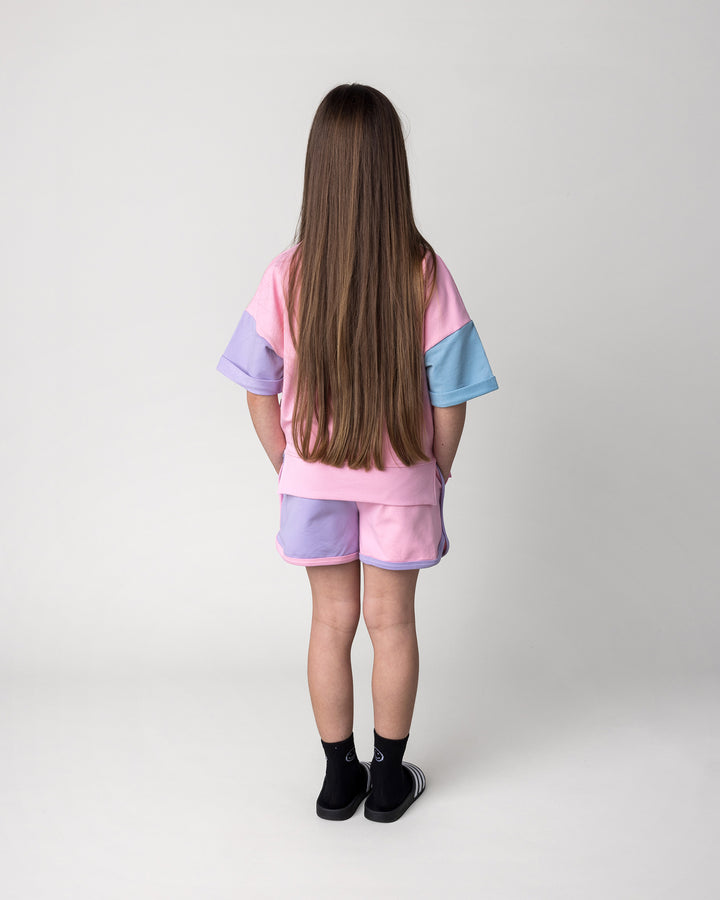 Kid wearing the Sprint Short in pink, purple and aqua with the Unicorn Club Short Sleeve Crew in pink, purple and aqua, back view