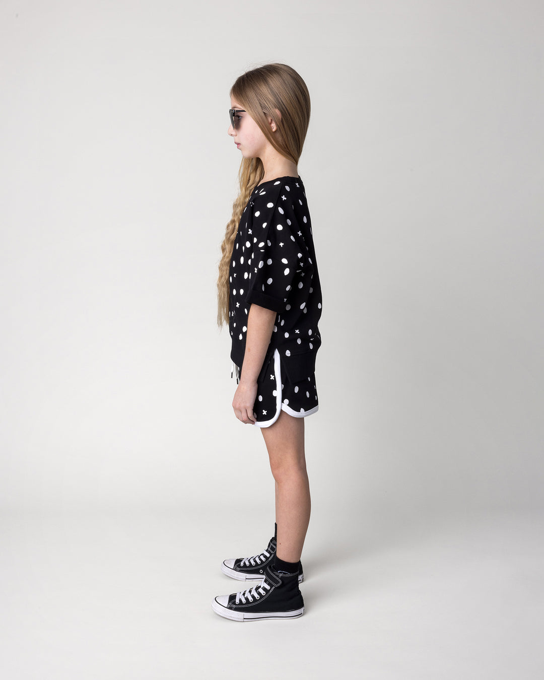 Kid wearing the Spotty Short in black and white with the Spotty Short Sleeve Crew in black, side view