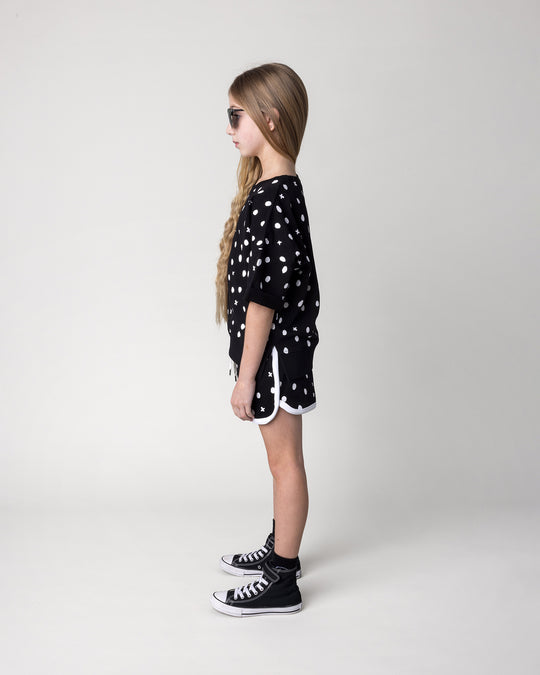 Kid wearing the Spotty Short in black and white with the Spotty Short Sleeve Crew in black, side view