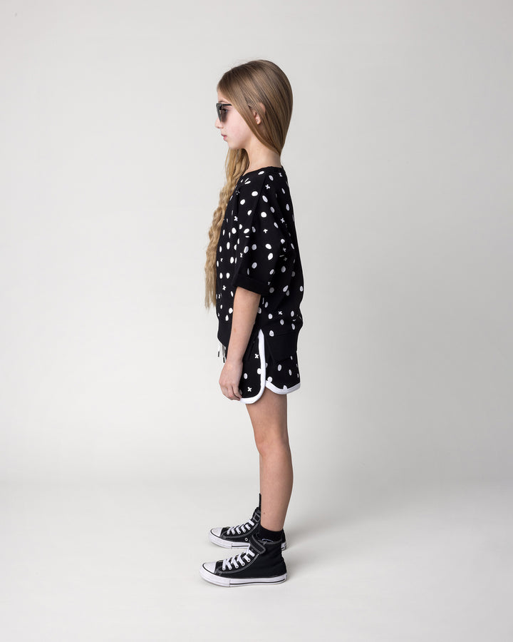 Kid wearing the Spotty Short in black and white with the Spotty Short Sleeve Crew in black, side view