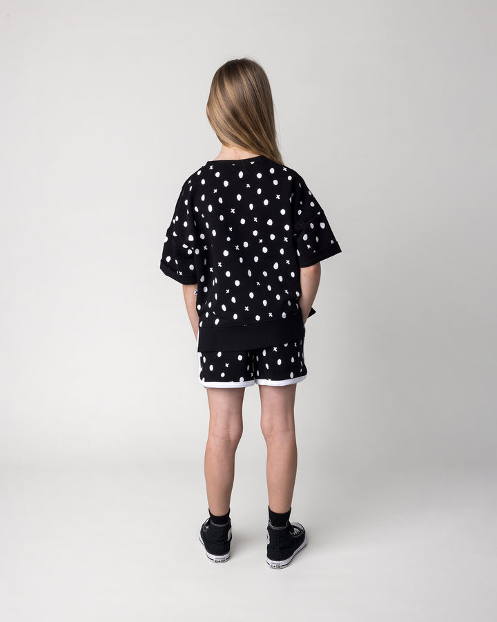 Kid wearing the Spotty Short in black and white with the Spotty Short Sleeve Crew in black, back view