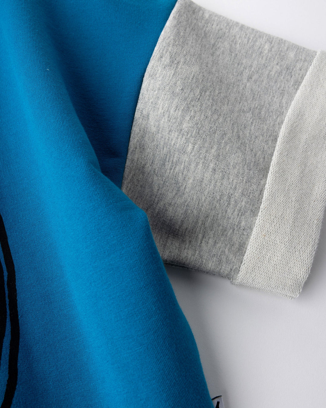 Close up detail of the Chill Sloth Short Sleeve Crew in teal, orange and grey marle