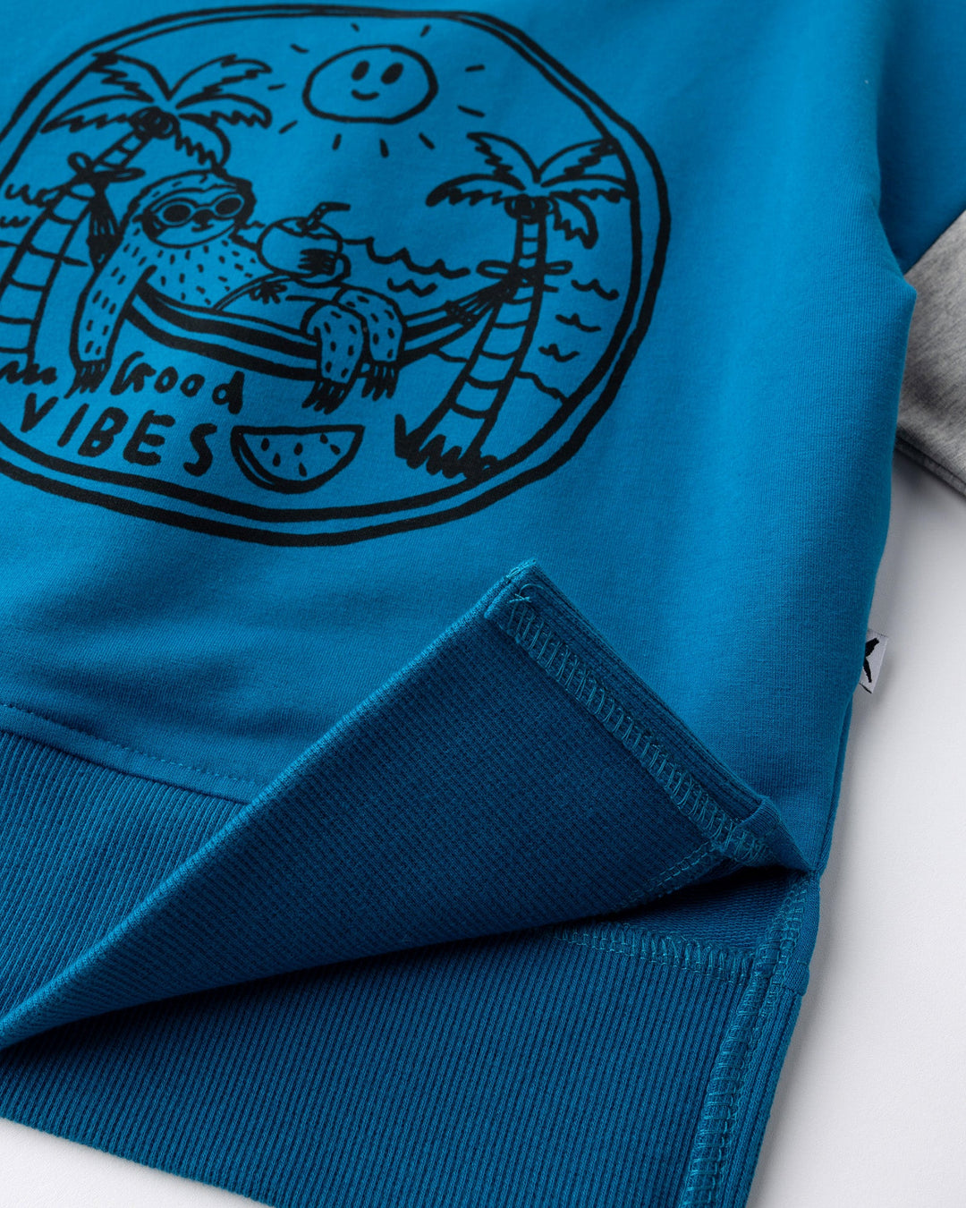 Close up detail of the Chill Sloth Short Sleeve Crew in teal, orange and grey marle
