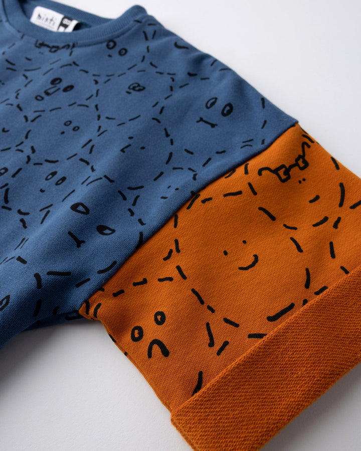 Close up detail of the Different Faces Short Sleeve Crew in navy, grey marle and orange