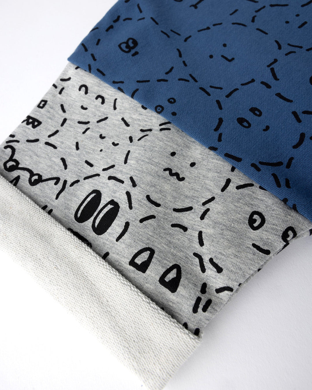 Close up detail of the Different Faces Short Sleeve Crew in navy, grey marle and orange