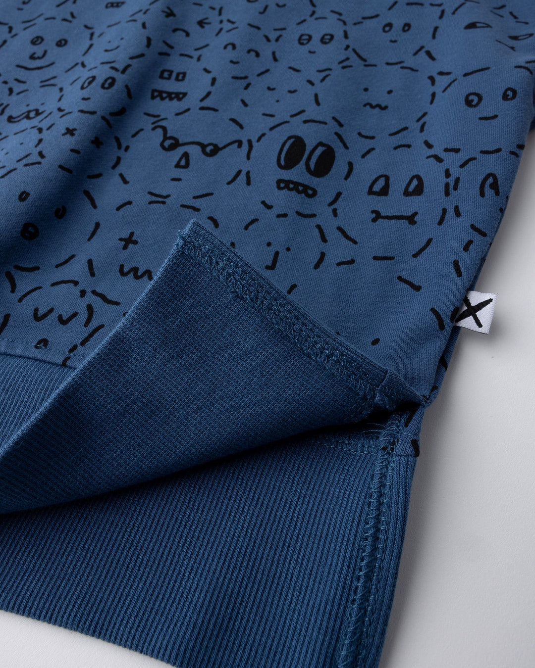 Close up detail of the Different Faces Short Sleeve Crew in navy, grey marle and orange