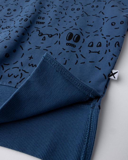 Close up detail of the Different Faces Short Sleeve Crew in navy, grey marle and orange