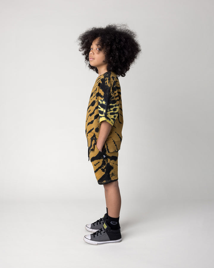 Kid wearing the Duo Tie Dye Short Sleeve Crew in lemon and rust with the Duo Tie Dye Short in lemon and rust, side view