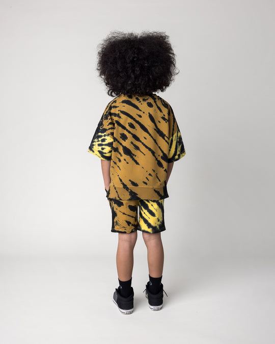 Kid wearing the Duo Tie Dye Short Sleeve Crew in lemon and rust with the Duo Tie Dye Short in lemon and rust, back view