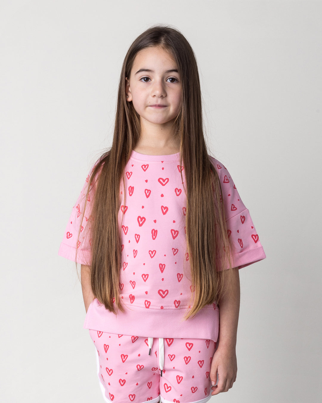 Close up of the Hearts Short Sleeve Crew in pink on a kid, front view