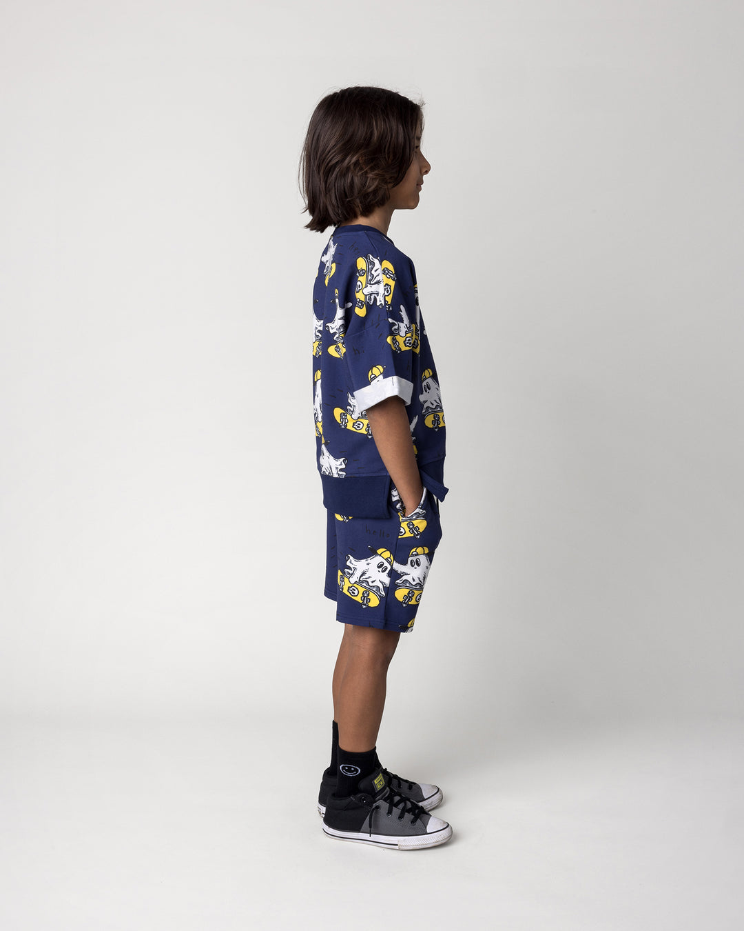 Kid wearing the Skate Ghost Short Sleeve Crew in dark blue with the Skate Ghost Short in dark blue, side view