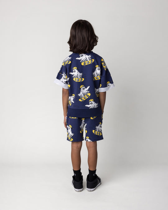 Kid wearing the Skate Ghost Short Sleeve Crew in dark blue with the Skate Ghost Short in dark blue, back view