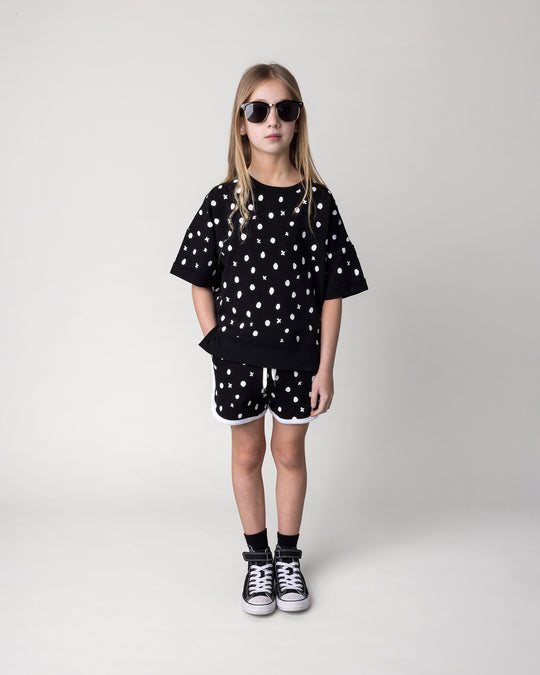 Kid wearing the Spotty Short Sleeve Crew in black with the Spotty Short in black and white, front view
