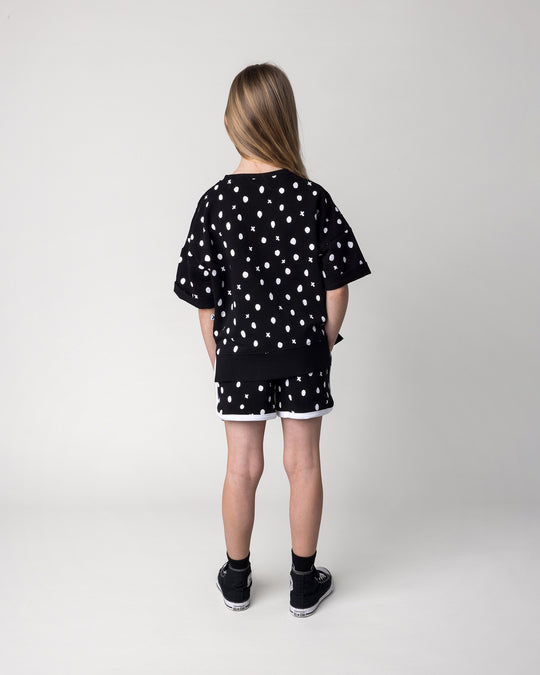 Kid wearing the Spotty Short Sleeve Crew in black with the Spotty Short in black and white, back view