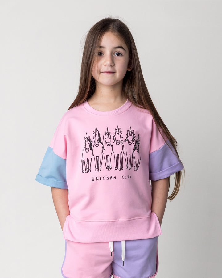 Close up of the Unicorn Club Short Sleeve Crew in pink, purple and aqua on a kid, front view