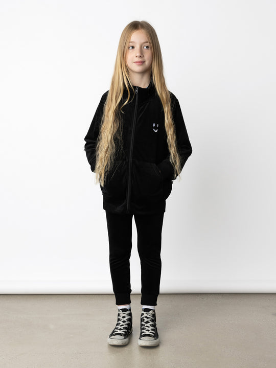 Minti kids clothing. Super cosy and soft zip up high neck crew, made in super soft velvet. Front kangaroo pocket to keep hands warm. Small Happy Face embroidery on the front. 92% Polyester // 8% Spandex.