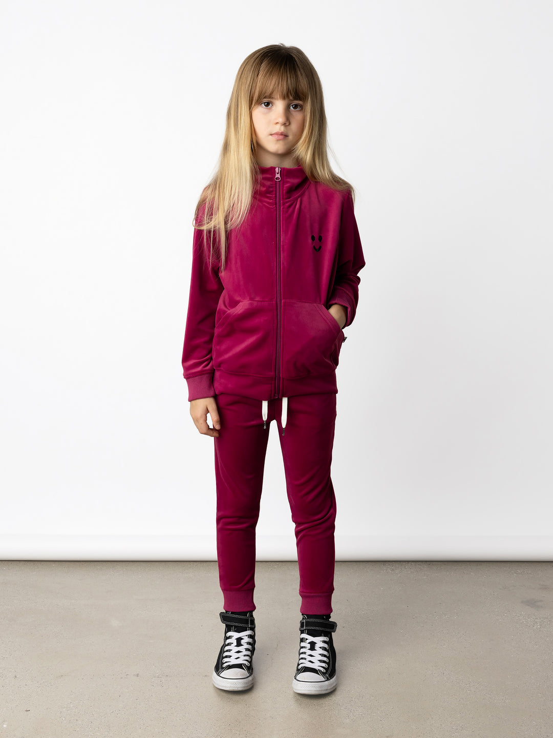 Minti kids clothing. Super cosy and soft zip up high neck crew, made in super soft velvet. Front kangaroo pocket to keep hands warm. Small Happy Face embroidery on the front. 92% Polyester // 8% Spandex.