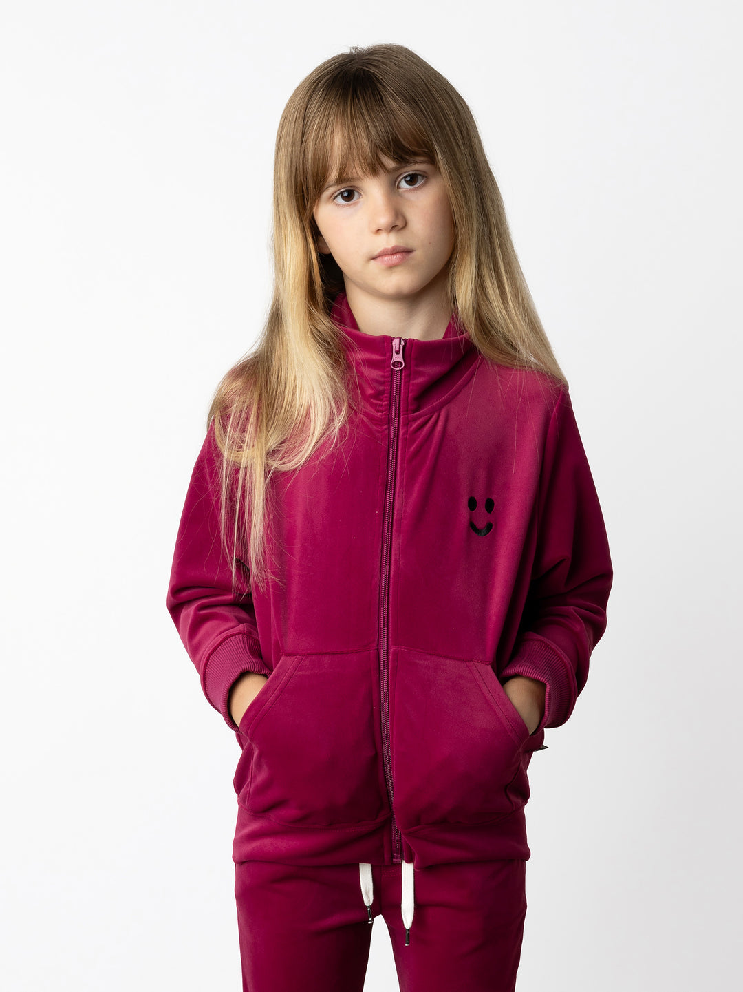 Minti kids clothing. Super cosy and soft zip up high neck crew, made in super soft velvet. Front kangaroo pocket to keep hands warm. Small Happy Face embroidery on the front. 92% Polyester // 8% Spandex.