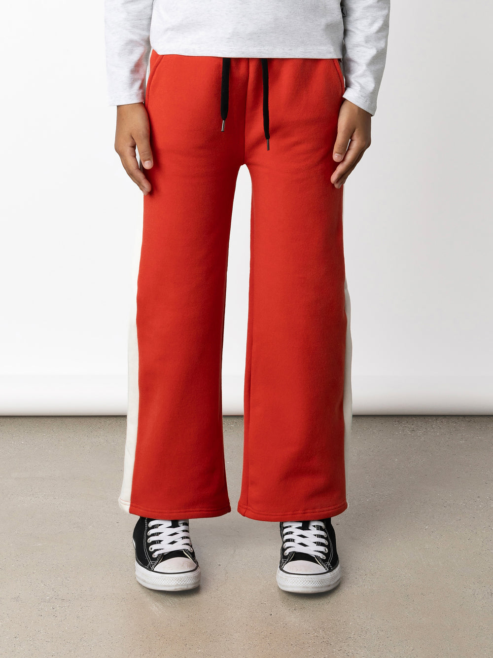 Minti kids clothing. Super relaxed fit wide leg trackies with cool contrast side panel. Elasticated waistband with shoelace cord, and front pockets to keep hands warm. Small Minti embroidery on the back. 330 Gram // Brushed Inside // 95% Cotton // 5% Elastane.