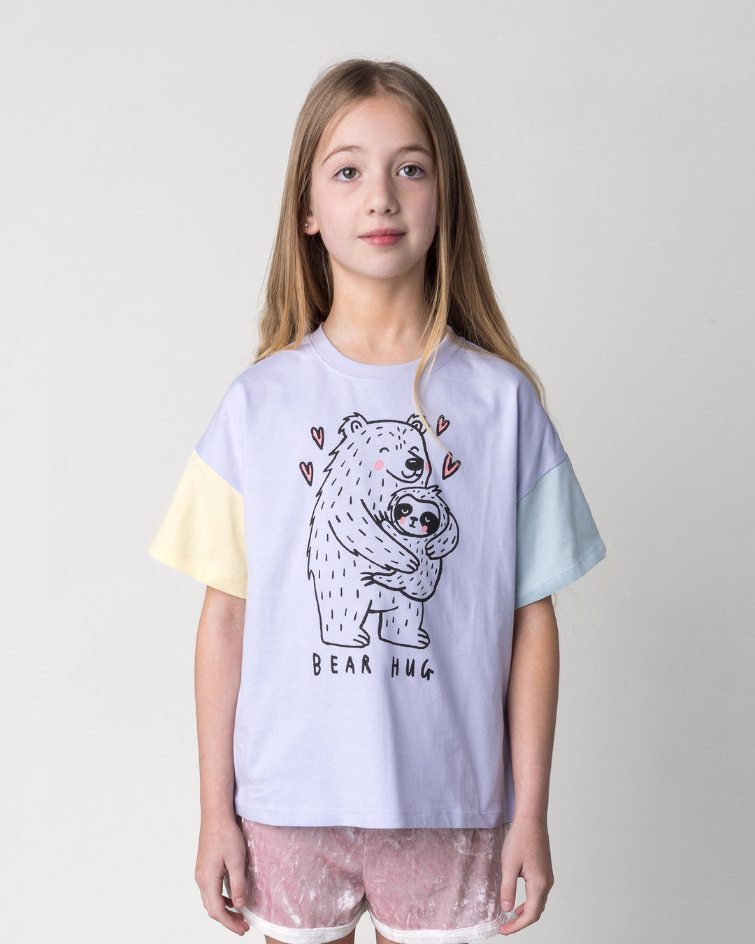 Close up of the Bear Hug Tee in lilac, lemon and blue on a kid, front view