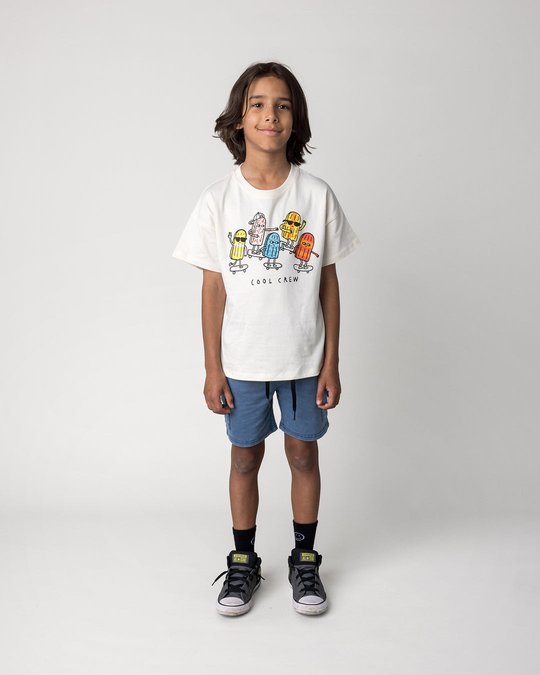 Kid wearing the Cool Crew Tee in cream with the Blasted Deluxe Cargo Short in midnight wash, front view