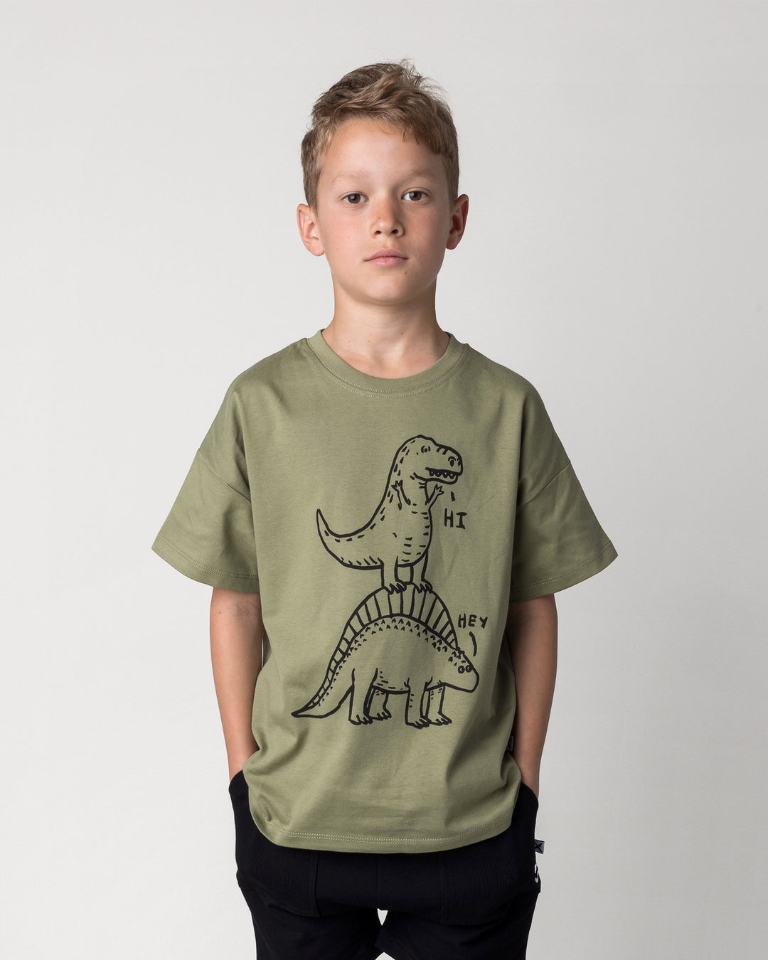 Close up of the Dino Ride Tee in light khaki on a kid, front view