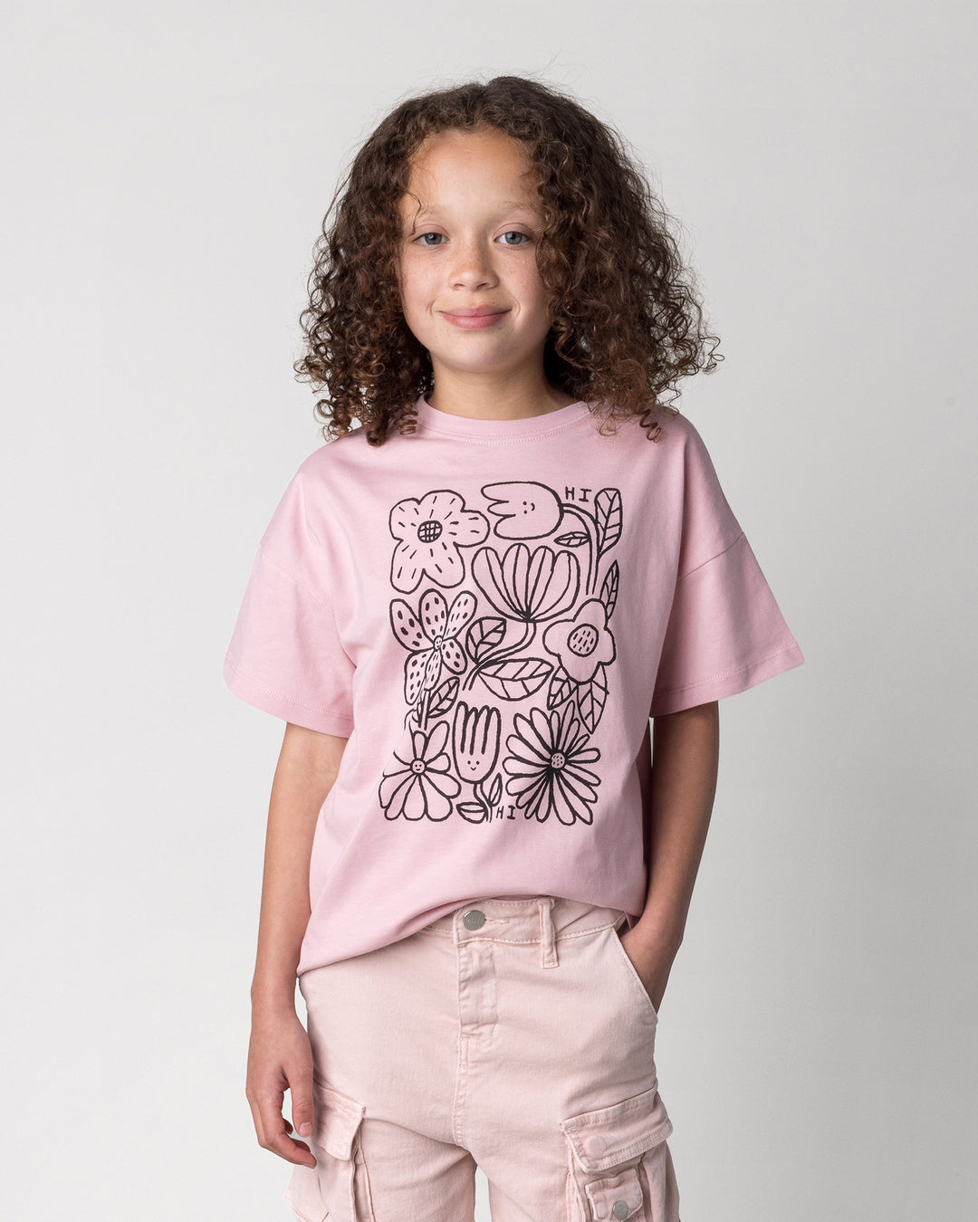 Close up of the Flower Party Tee in muted pink on a kid, front view