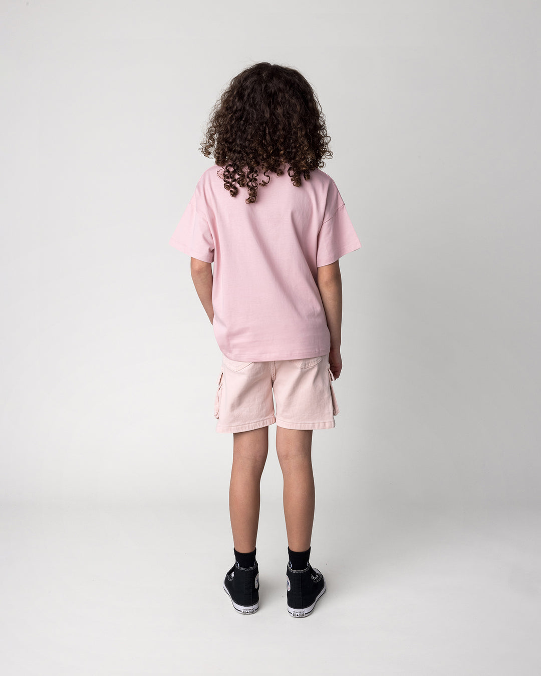 Kid wearing the Flower Party Tee in muted pink, back view