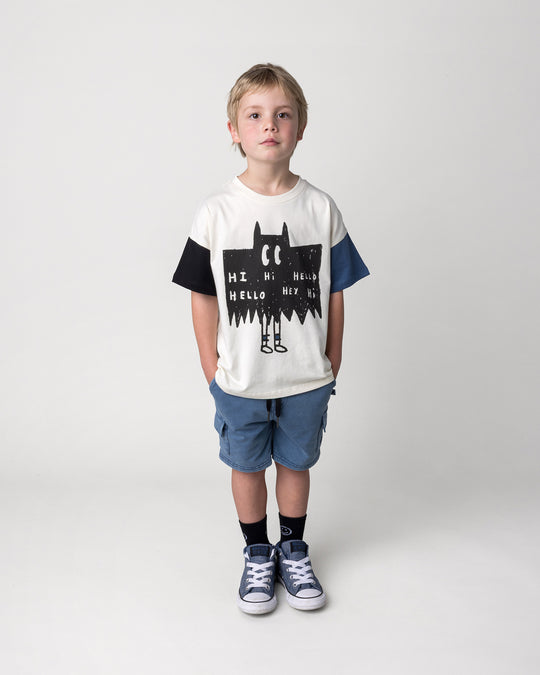 Kid wearing the Greetings Bat Tee in cream, black and midnight with the Blasted Deluxe Cargo Short in midnight wash, front view