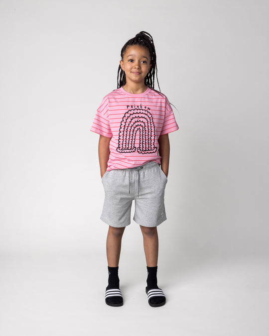 Kid wearing the Happy Rainbow Tee in pink and red stripe with the Smile Short in grey marle, front view