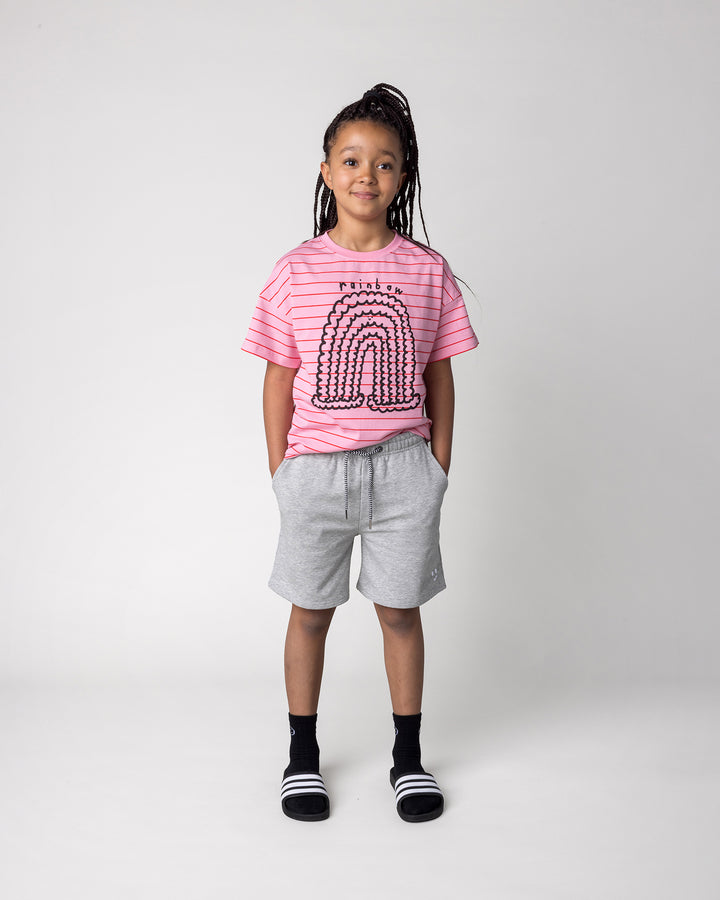 Kid wearing the Happy Rainbow Tee in pink and red stripe with the Smile Short in grey marle, front view