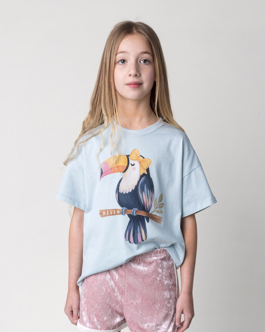 Close up of the Hello Toucan Tee in light blue on a kid, front view