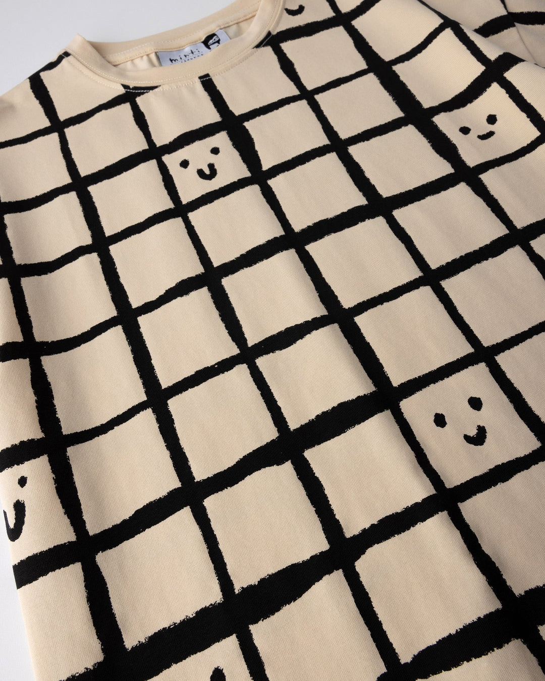 Close up of the Happy Squares Tee print in beige