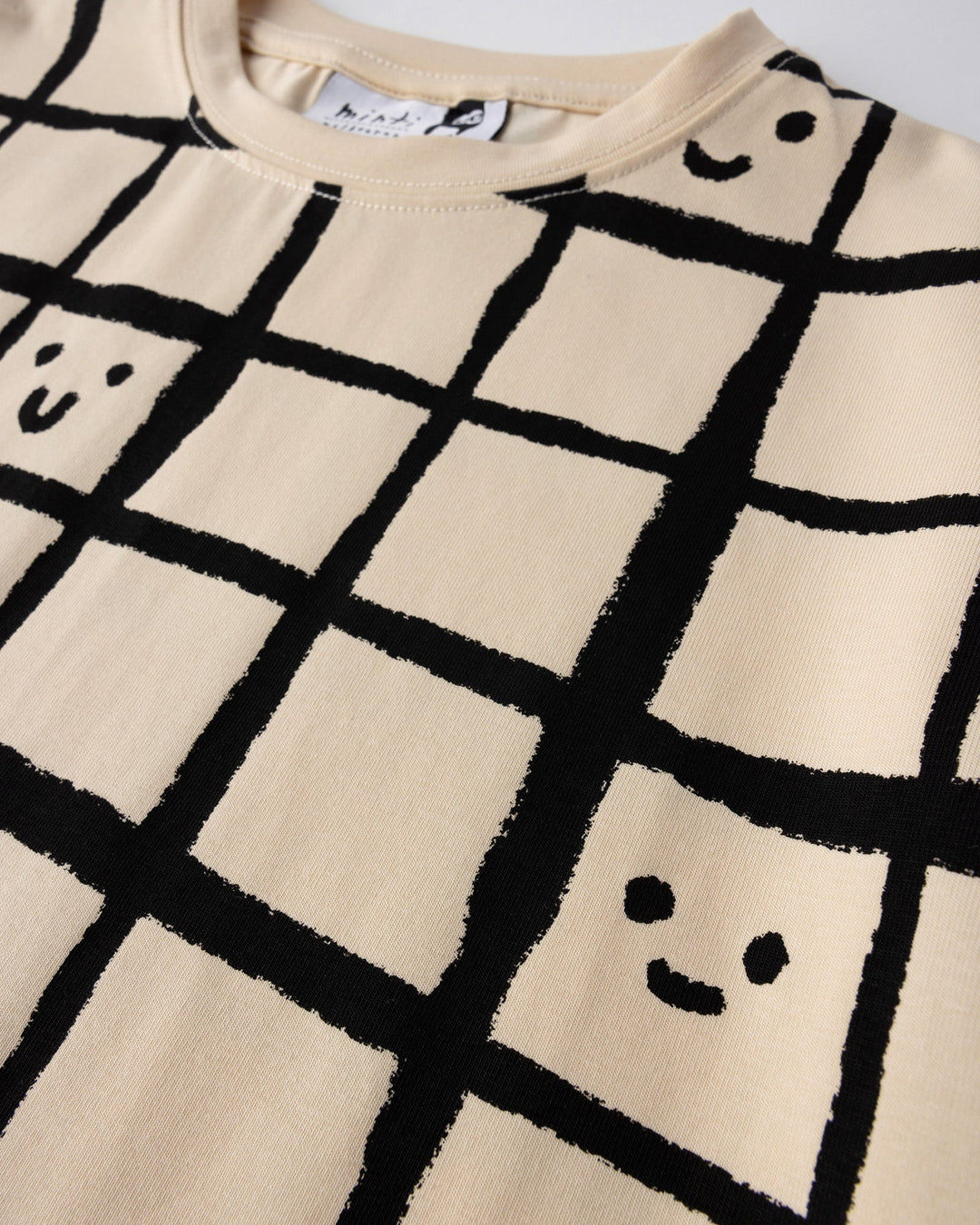 Close up of the Happy Squares Tee print in beige