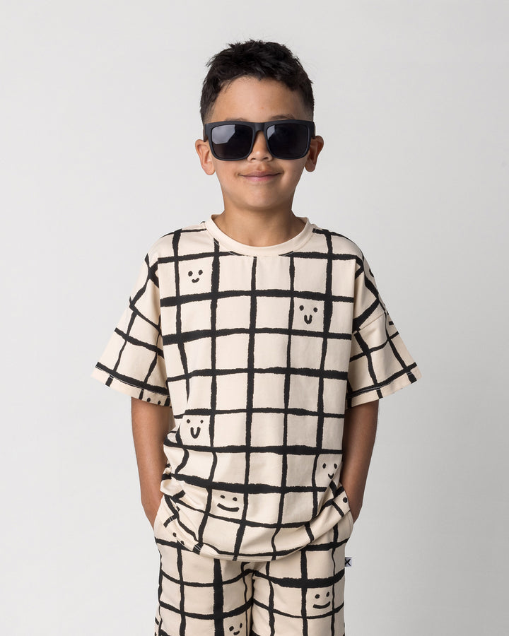 Close up of the Happy Squares Tee in beige on a kid, front view