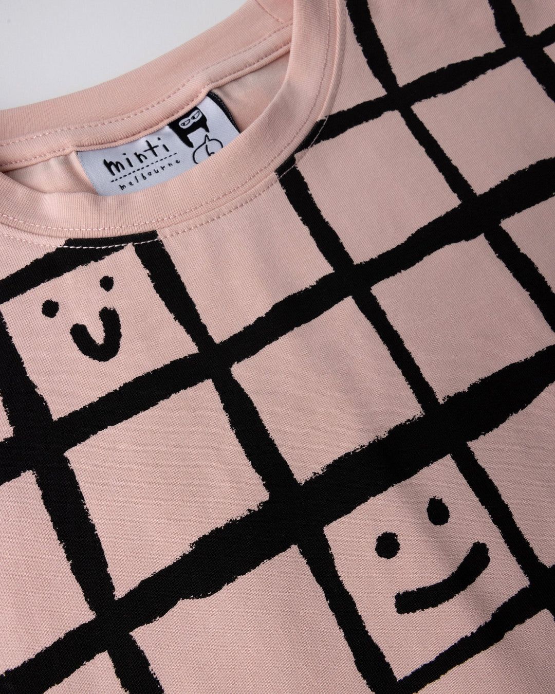 Close up detail of the Happy Squares Tee in dusty pink