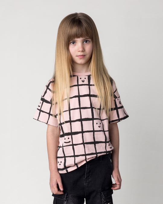 Close up of the Happy Squares Tee in dusty pink on a kid, front view