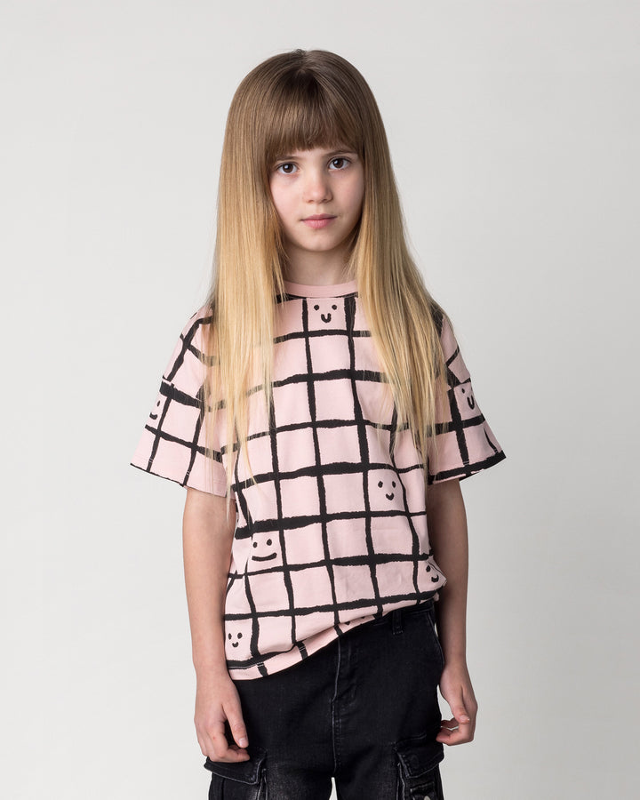 Close up of the Happy Squares Tee in dusty pink on a kid, front view